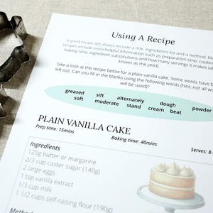 Puede incluir: Se muestra una receta de bizcocho de vainilla con cortadores de galletas con forma de ciervo y casa. La receta incluye ingredientes, tiempo de preparaci&oacute;n y tiempo de horneado. El texto "Using A Recipe" est&aacute; en la parte superior.