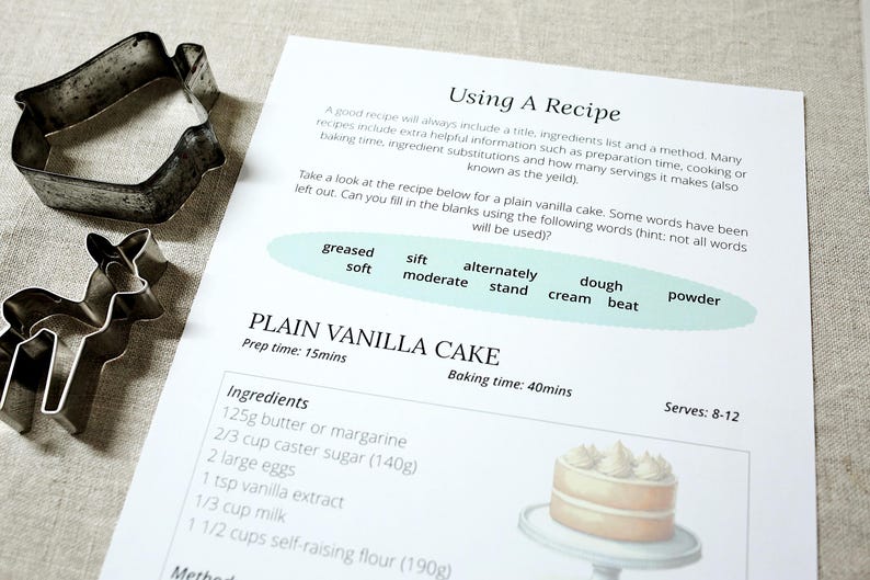Puede incluir: Se muestra una receta de bizcocho de vainilla con cortadores de galletas con forma de ciervo y casa. La receta incluye ingredientes, tiempo de preparaci&oacute;n y tiempo de horneado. El texto "Using A Recipe" est&aacute; en la parte superior.