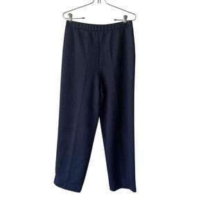 May include: Dark navy blue trousers hanging on a metal hanger. The trousers have a straight leg design and a simple, elastic waistband. The fabric appears to be a medium-weight material, suitable for various seasons. The trousers are displayed against a plain white background.