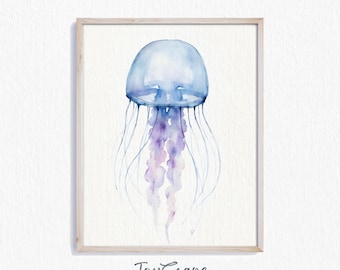 以下が含まれることがあります： 額縁に入ったクラゲの水彩画プリント。クラゲは主に青色で、触手に紫色のアクセントがあります。作品は下部に筆記体フォントで「JoyScape Studio」と署名されています。
