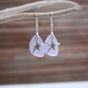Puede incluir: Un par de pendientes de plata con forma de l&aacute;grima de vidrio lavanda y un dije de estrella de mar de plata.