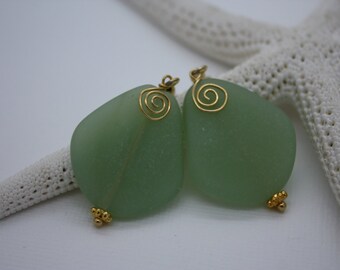 May include: A pair of green sea glass earrings with gold wire spirals and gold bead accents.