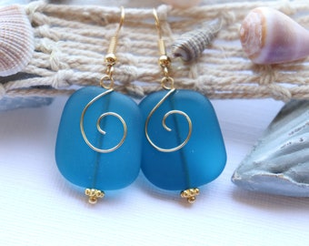 May include: Teal blue glass earrings with gold wire swirls and gold beads.
