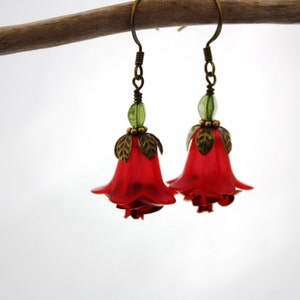 May include: Red flower shaped earrings with green accents and bronze details.
