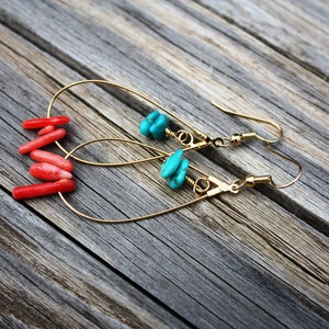 May include: A pair of gold hoop earrings with turquoise and coral stones. The earrings are dangling and have a simple design.