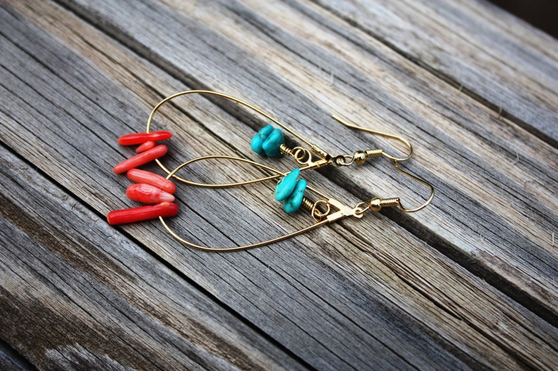 May include: A pair of gold hoop earrings with turquoise and coral stones. The earrings are dangling and have a simple design.