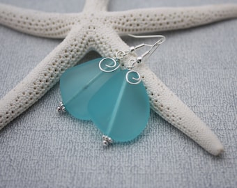May include: A pair of earrings with frosted blue glass teardrop shaped pendants and silver wire accents.
