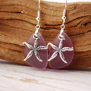 Puede incluir: Un par de pendientes colgantes con forma de l&aacute;grima de vidrio morado y un dije de estrella de mar plateado.