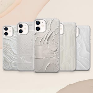 Könnte beinhalten: Eine Sammlung von fünf weißen Handyhüllen mit strukturierten Designs. Die Hüllen weisen verschiedene Muster auf, darunter wellenförmige Linien, vertikale Streifen und abstrakte Pinselstrich-Texturen. Die Hüllen sind für ein Smartphone konzipiert.