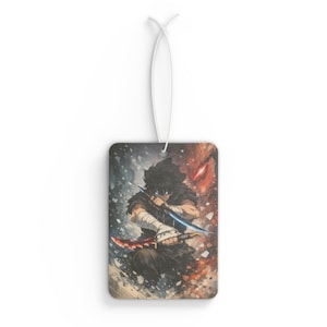 May include: Rectangular air freshener featuring an anime-style illustration of a character wielding two swords. The character has black hair and blue eyes, set against a backdrop of blue and red hues. A white string is attached for hanging.