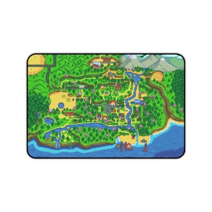 以下が含まれることがあります： 川、木、建物、山がある田園風景のカラフルなピクセル化された地図が描かれた長方形のマウスパッド。 デザインには、桟橋と町に通じる道路がある海岸エリアが含まれています。 マウスパッドには黒い縁があります。