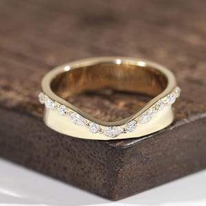Anel feminino em ouro maciço 14k com moissanita e diamantes, com curvatura profunda, aro grosso cravejado de pavé, formato em U e design em V. Ideal para noivas.