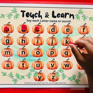 May include: A laminated educational sheet titled Touch & Learn featuring rows of orange pumpkin illustrations, each labeled with a lowercase letter from a to z. Red buttons are placed on some pumpkins, and green vine graphics border the page.