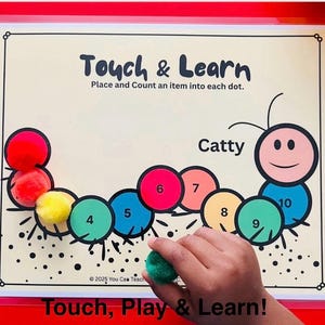 May include: Educational learning mat with a caterpillar design. The mat features colorful circles numbered 4 through 10, and a smiling caterpillar face. The text "Touch & Learn" and "Touch, Play & Learn!" are displayed.