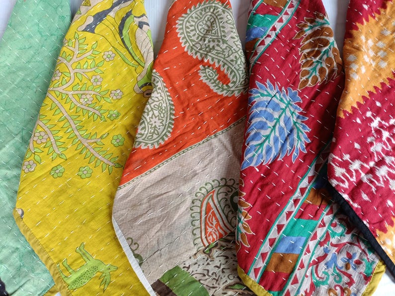 Puede incluir: Una colecci&oacute;n de piezas de tela coloridas y estampadas. Las telas presentan varios dise&ntilde;os, incluyendo motivos florales y paisley, en tonos verdes, amarillos, naranjas y rojos. Cada pieza est&aacute; cosida con un hilo contrastante, creando un efecto texturizado.
