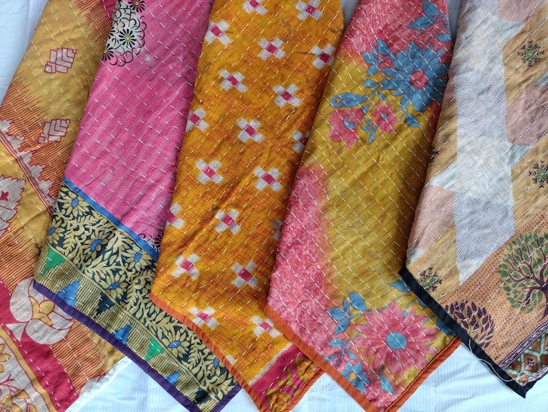 Pode incluir: Uma cole&ccedil;&atilde;o de pe&ccedil;as de tecido coloridas e estampadas. Os t&ecirc;xteis apresentam v&aacute;rios desenhos, incluindo padr&otilde;es florais e geom&eacute;tricos, em tons de rosa, amarelo e laranja. Cada pe&ccedil;a tem uma borda &uacute;nica com detalhes intrincados.