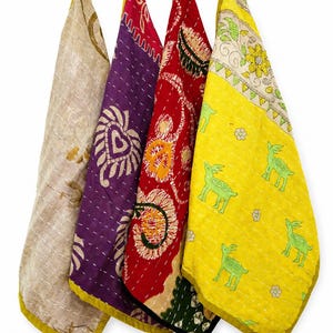 May include: Four rectangular fabric pieces featuring intricate kantha stitching. The first is beige with subtle patterns, the second is purple with a heart motif, the third is red with floral designs, and the fourth is yellow with green deer prints.