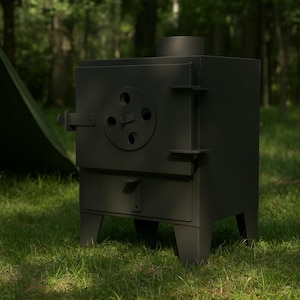 Può includere: Una stufa da campeggio in metallo nero con porta rotonda e camino è su erba verde. Una tenda verde è parzialmente visibile sullo sfondo, con alberi in lontananza. La stufa ha un piccolo cassetto e un chiavistello.