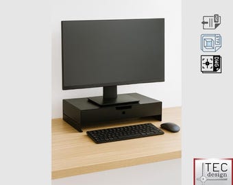 May include: A black computer monitor sits above a black monitor stand with a drawer. A black keyboard and mouse are on the light wood desk. The image also includes a logo that says "TEC design".