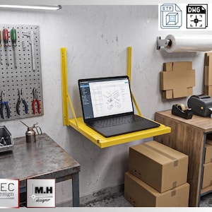 May include: A yellow, wall-mounted folding shelf supports a black laptop displaying a technical diagram. The workspace includes tools, packaging supplies, and a label printer, suggesting a workshop or small business setting.