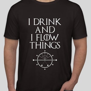 Peut inclure: T-shirt noir avec le texte blanc "I DRINK AND I FLOW THINGS" et un graphique circulaire. Le graphique comprend des lignes, des cercles et un motif central. Un vêtement décontracté.