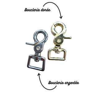 K&ouml;nnte beinhalten: Zwei Metall-Karabinerhaken, einer silberfarben und einer goldfarben, vor wei&szlig;em Hintergrund. Der goldfarbene Haken ist mit "Bouclerie dor&eacute;e" und der silberfarbene Haken mit "Bouclerie argent&eacute;e" beschriftet.