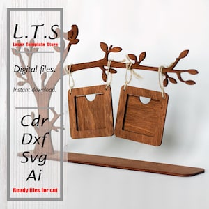 Peut inclure: Un présentoir photo en bois avec un design de branche d'arbre. Deux cadres carrés sont suspendus à la branche avec de la ficelle. Le présentoir comprend le texte "L.T.S Laser Template Store" et "Digital files. Instant download. Ready files for cut."