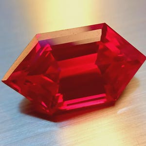 Puede incluir: Una gema roja facetada con una forma geométrica única. La gema tiene una superficie brillante y reflectante, que captura la luz y crea un juego de sombras. Los bordes de la gema están cortados con precisión, mostrando su claridad y color.