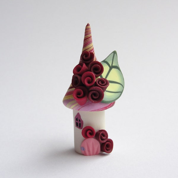 Miniature fairy house home made from polymer clay in yellow, pink and red