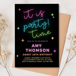 A close-up of a party invitation with a dark background, colorful text, and a decorative ribbon, set on a textured surface.