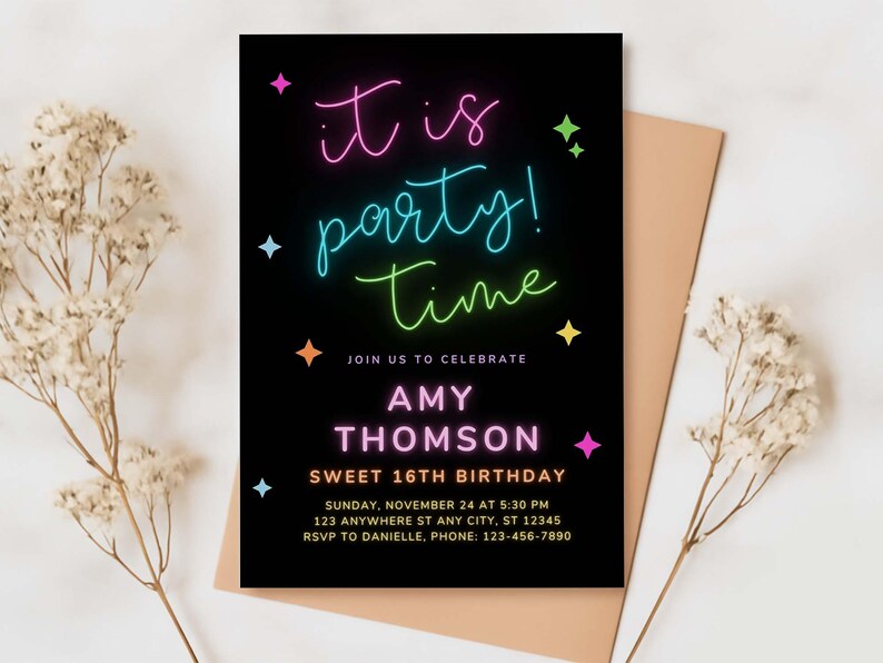 A close-up of a party invitation with a dark background, colorful text, and a decorative ribbon, set on a textured surface.
