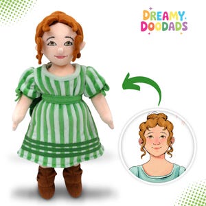 May include: A plush doll of a woman with red hair, wearing a green and white striped dress and brown boots. The doll has a smiling face and is holding a small green bag. The image includes a cartoon drawing of the doll's face and the text "Dreamy Doodads".