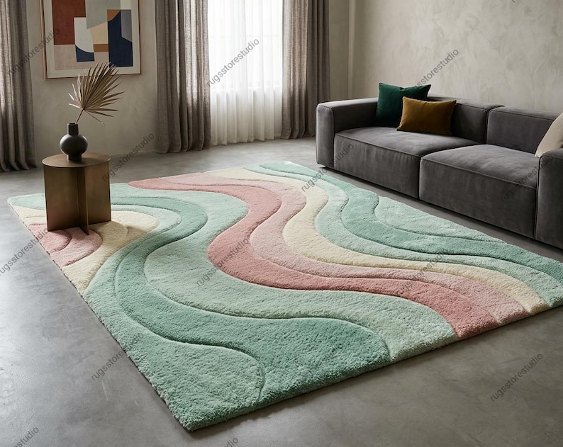 Wavy pattern retro 70s style area rug with 3D carved high-low pile texture featuring pastel pink, sage green, and cream colors on a living room floor.