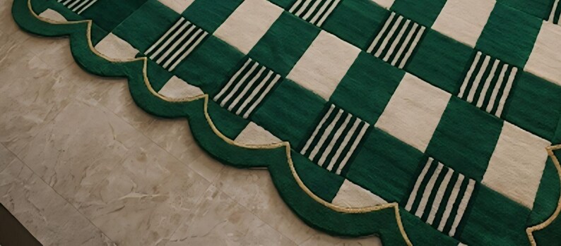 May include: A green and white checkered rug with a scalloped edge. The rug features alternating squares of solid green and white, with some green squares containing black and white stripes. The edge is green with a gold trim.