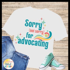 Puede incluir: Una camiseta blanca con el texto "Sorry (not sorry) for advocating" en turquesa y naranja. La imagen incluye vaqueros azules y zapatillas de deporte verde menta con cordones y suelas blancas. El fondo es de madera.