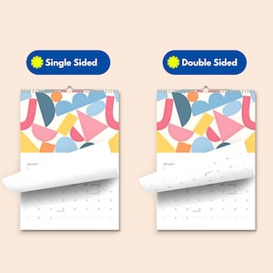 Puede incluir: Dos calendarios de pared con encuadernaci&oacute;n en espiral en la parte superior. El calendario izquierdo est&aacute; etiquetado como Single Sided y el derecho como Double Sided. Ambos muestran formas geom&eacute;tricas coloridas y una cuadr&iacute;cula de enero.