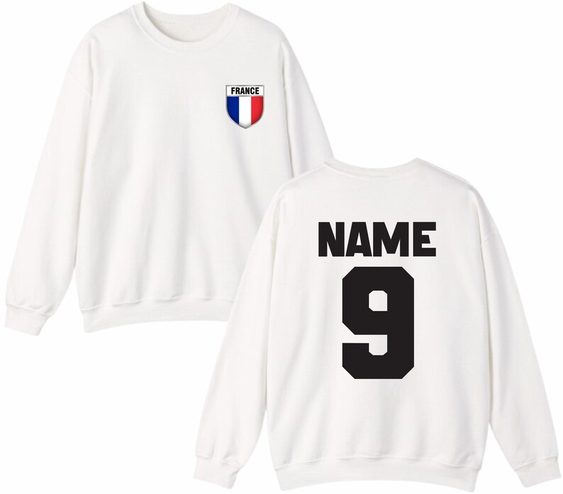 May include: White sweatshirt with a French flag emblem on the chest and the word "FRANCE" above it. The back of the sweatshirt features the word "NAME" above the number "9" in black. A casual, sporty design.