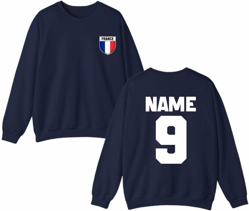 May include: Navy blue sweatshirt with the French flag emblem on the chest. The back of the sweatshirt displays the word "NAME" above the number "9" in white block letters. A casual, sporty design.
