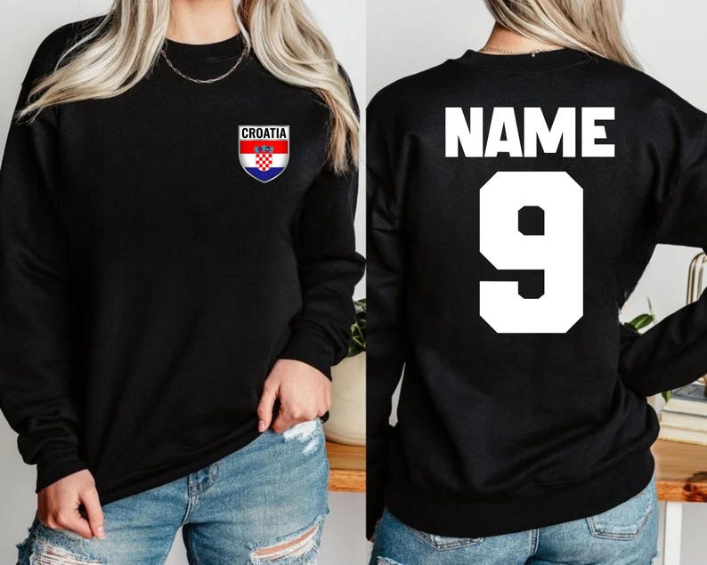 May include: Black sweatshirt with the word "CROATIA" above a Croatian flag emblem on the front. The back of the sweatshirt has the word "NAME" above the number "9" in white.