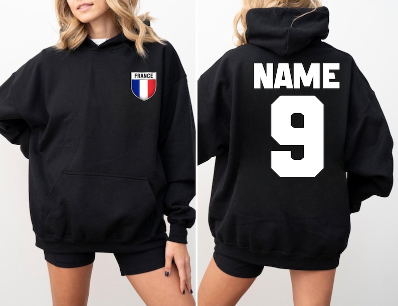 May include: Black hoodie with a front pocket and a hood. The front features a small patch with the French flag and the word "FRANCE". The back displays the word "NAME" above the number "9" in white block letters.