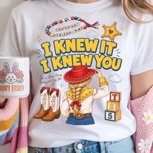 Puede incluir: Una camiseta blanca con un gr&aacute;fico de una persona con trenza rubia, sombrero de vaquero rojo, camisa amarilla y vaqueros azules. El dise&ntilde;o incluye botas vaqueras, una estrella, bloques de letras y el texto I KNEW IT I KNEW YOU.