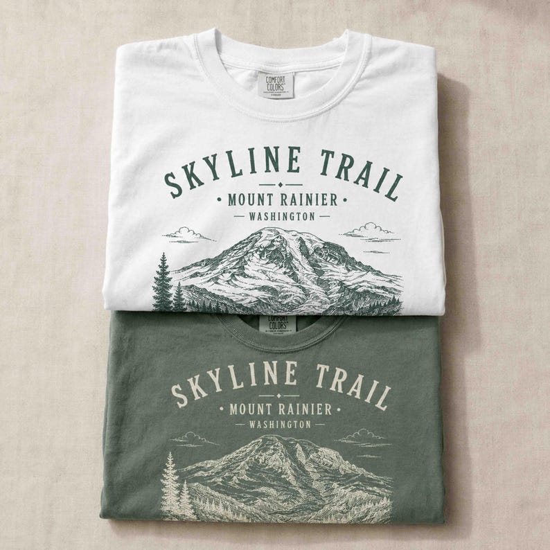 Folded Moss and White Comfort Colors shirts featuring a vintage Skyline Trail Mount Rainier design.