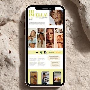 May include: A smartphone with a pink case displays a website with the text "HI IM ELLA!" and a grid of images. The website features a light yellow and white color scheme with images of a woman and text about skincare, food, and content creation.