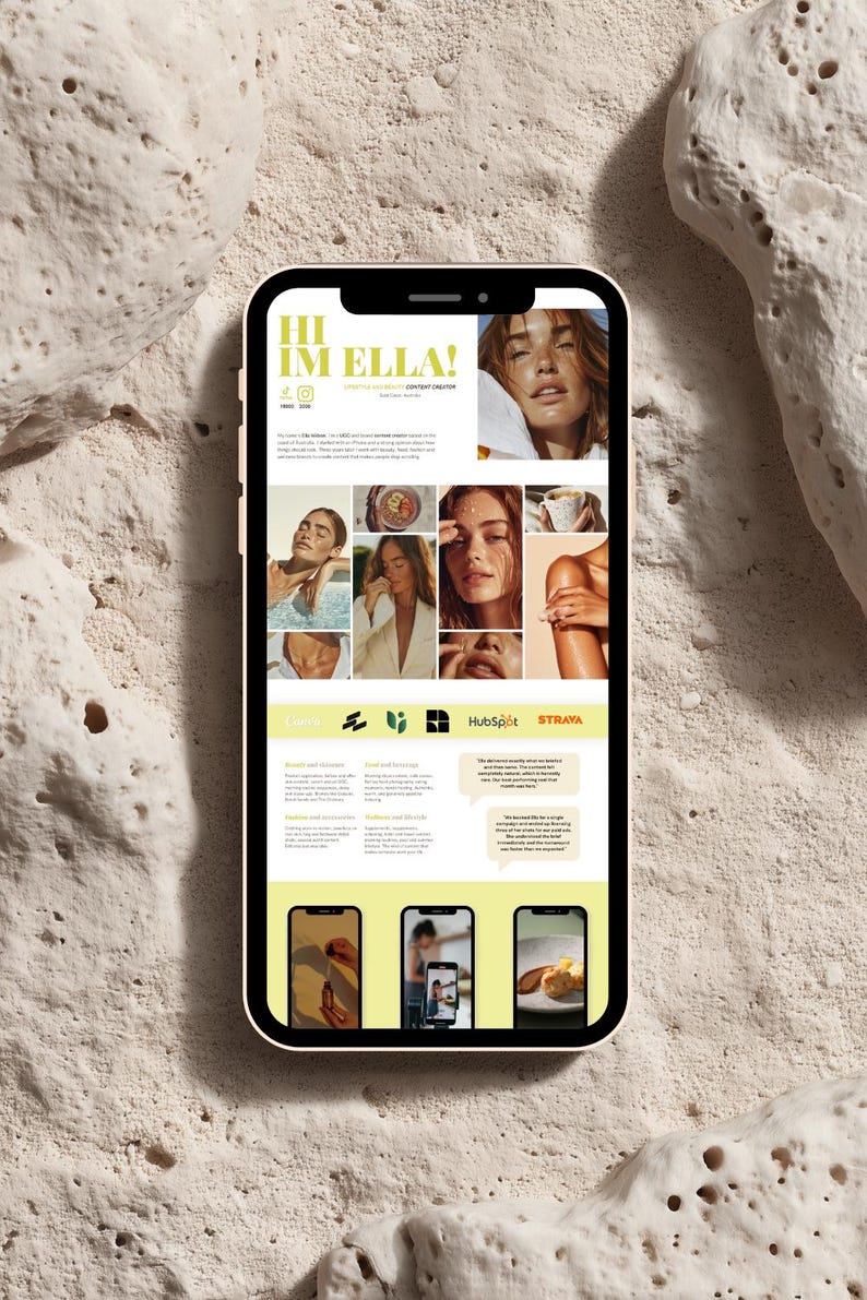May include: A smartphone with a pink case displays a website with the text "HI IM ELLA!" and a grid of images. The website features a light yellow and white color scheme with images of a woman and text about skincare, food, and content creation.