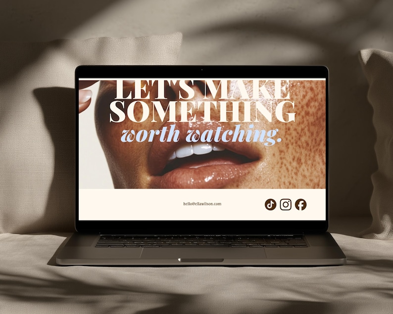 May include: A laptop screen displaying a webpage with a close-up image of a person's mouth and freckled skin. The text reads LET'S MAKE SOMETHING worth watching. Below is the email address hello@ellawilson.com and icons for TikTok, Instagram, and Facebook.