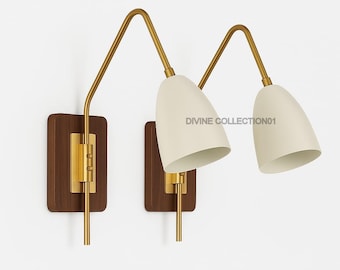 May include: Two wall sconces with a mid-century modern design. Each has a cream-coloured cone-shaped shade, a brass-coloured arm, and a rectangular wooden base. The text "DIVINE COLLECTION01" is visible on the right side.