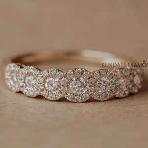 May include: A gold band ring with a series of round, sparkling diamonds. The diamonds are set closely together, creating a continuous row of brilliance. The ring is set against a neutral background, highlighting the ring's design. The text "KENDALL DIAMOND" is visible.