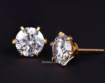 May include: A pair of sparkling diamond stud earrings with gold settings. The round-cut diamonds are set in a six-prong design, showcasing their brilliance. The earrings are displayed against a dark background, highlighting their sparkle.