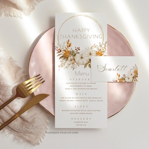 May include: Thanksgiving menu and place card with floral and pumpkin illustrations. The menu features a gold circular design with the words "Happy Thanksgiving" and a list of dishes. The place card has the name "Scarlett".