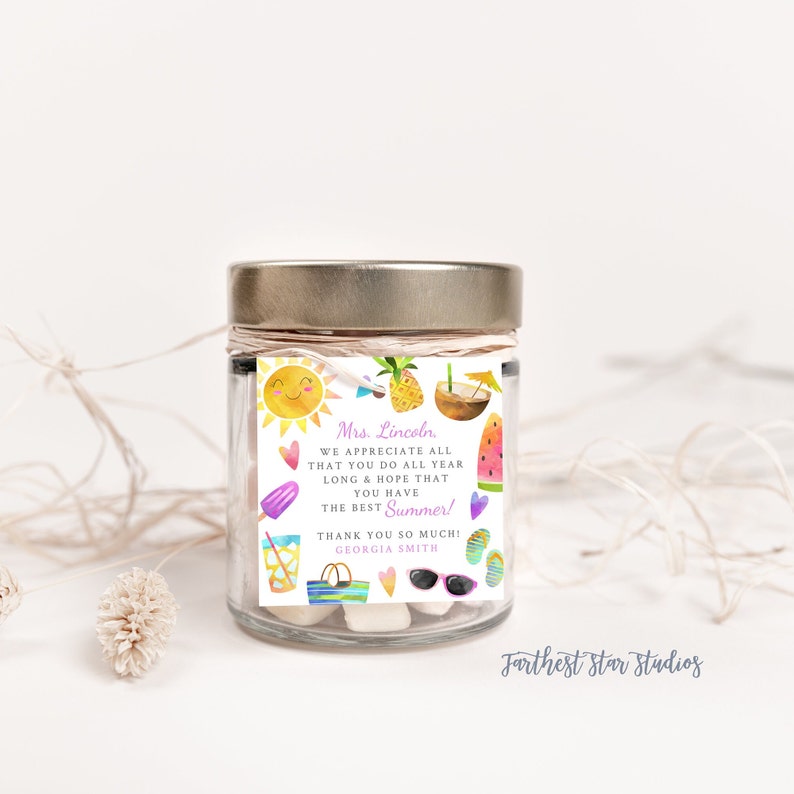 May include: A glass jar with a gold lid filled with white marshmallows and a colorful summer-themed gift tag that reads "Mrs. Lincoln. WE APPRECIATE ALL THAT YOU DO ALL YEAR LONG & HOPE THAT YOU HAVE THE BEST Summer! THANK YOU SO MUCH! GEORGIA SMITH"